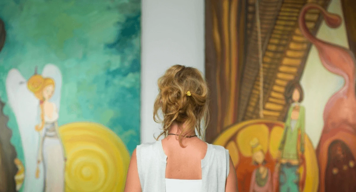 Woman staring at artwork on the wall 