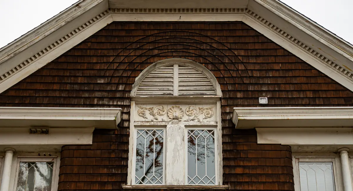 Wood shingled building with aging window trim