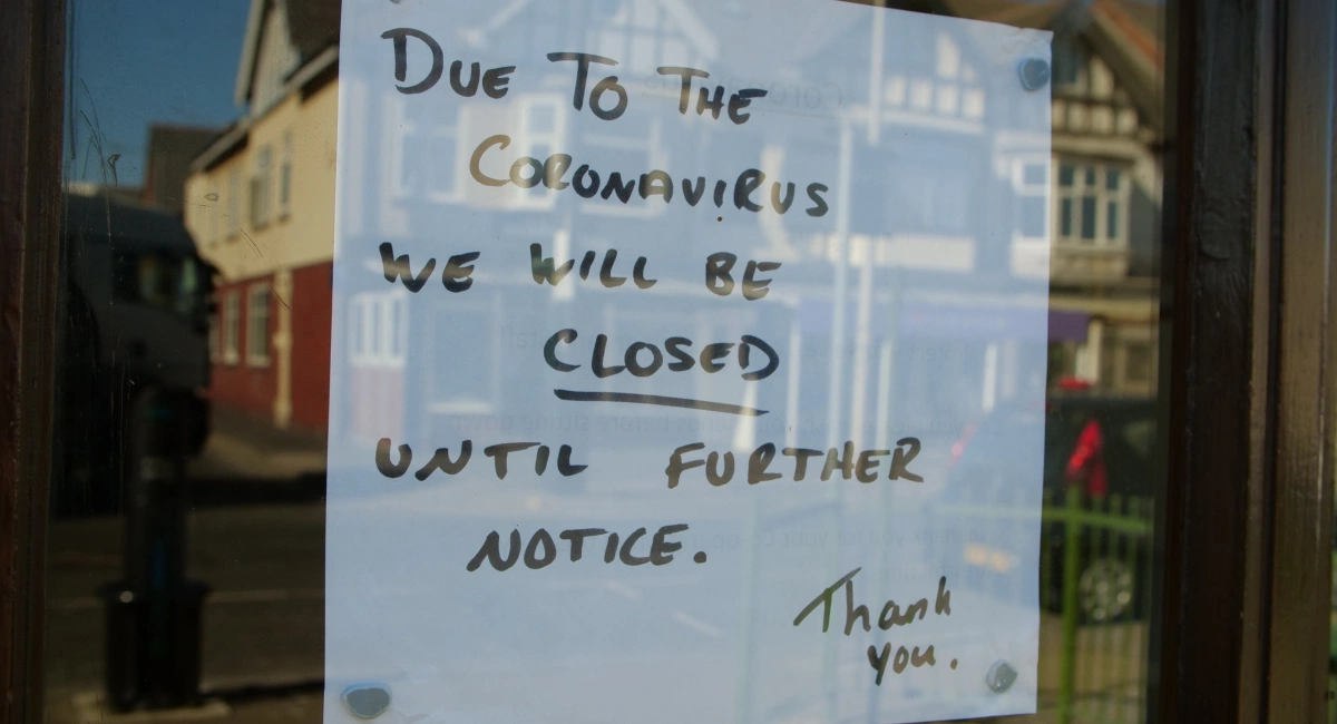 Sign on door alerting customers the shop will be closed till further notice during covid