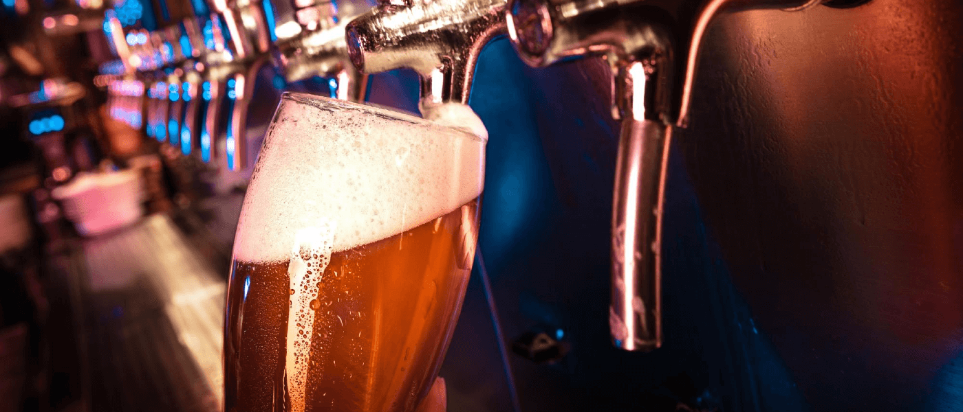A bartender pouring a beer from the tap