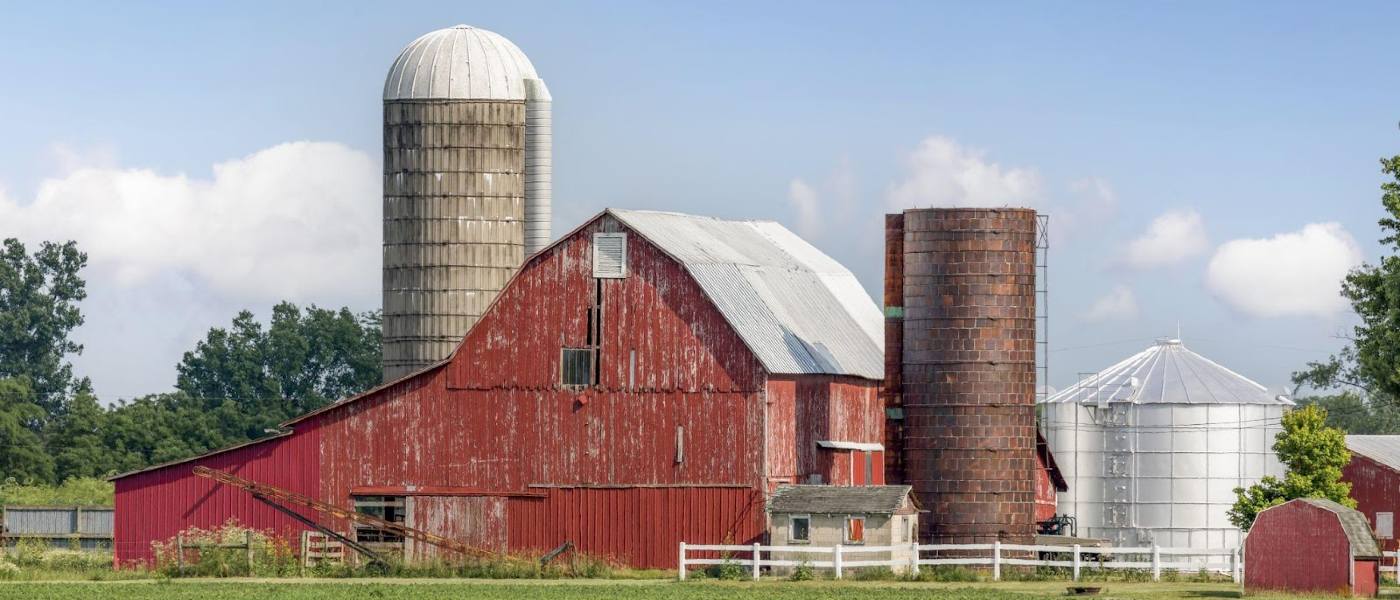 View of a farm featuring a large red barn and silo