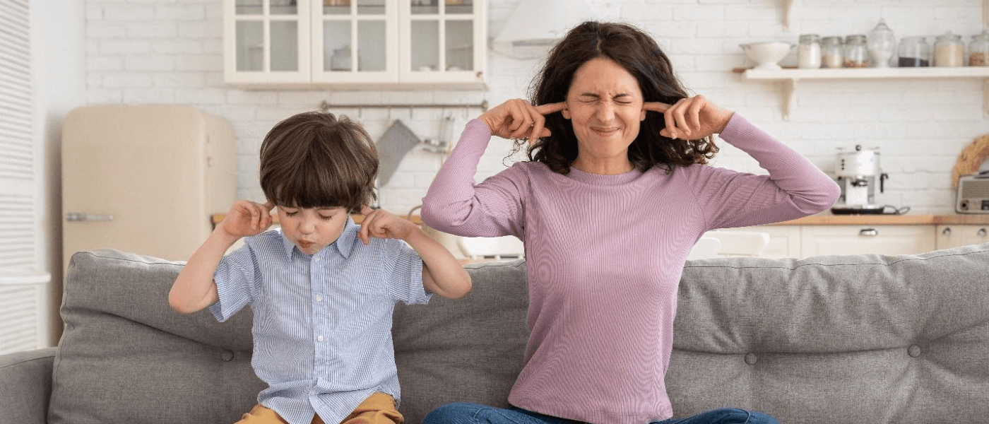 A mother and child blocking their ears from the chirping in the attic.