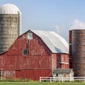 View of a farm featuring a large red barn and silo