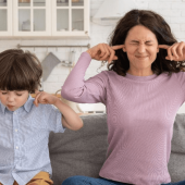 A mother and child blocking their ears from the chirping in the attic.