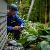 JP Pest Services technician inspecting the exterior of a multifamily property during a routine pest control check in New England.
