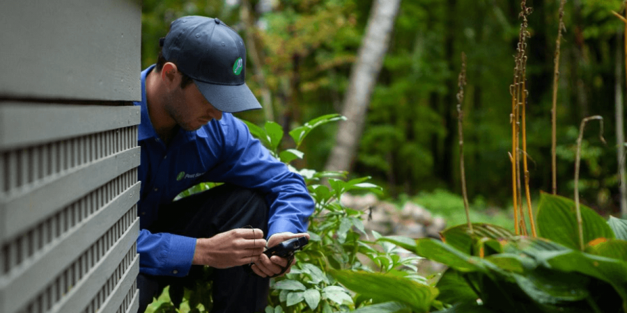 A JP Pest Services team member hard at work protecting a home from outdoor pests.